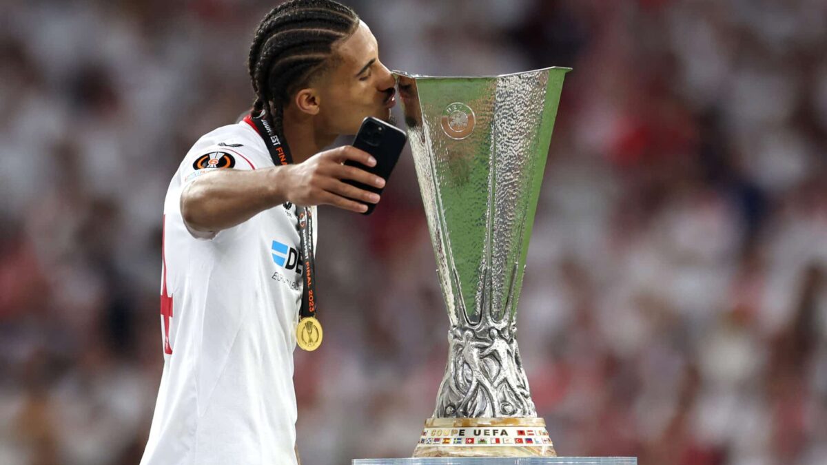 Loïc Badé poses with the Europa League trophy won with Sevilla